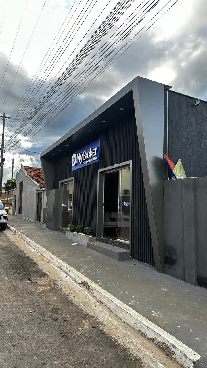 Fachada comercial em ACM preto com pórtico metálico